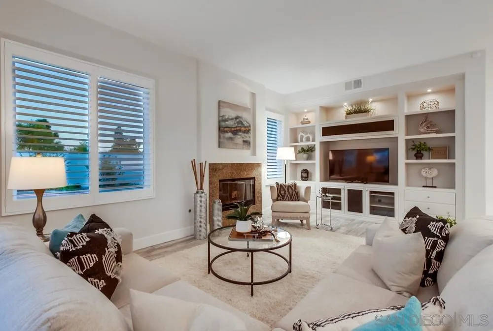 6814 Moorhen Place Carlsbad, CA 92011 - Photo 9 of 37 a living room with furniture a flat screen tv and a fireplace