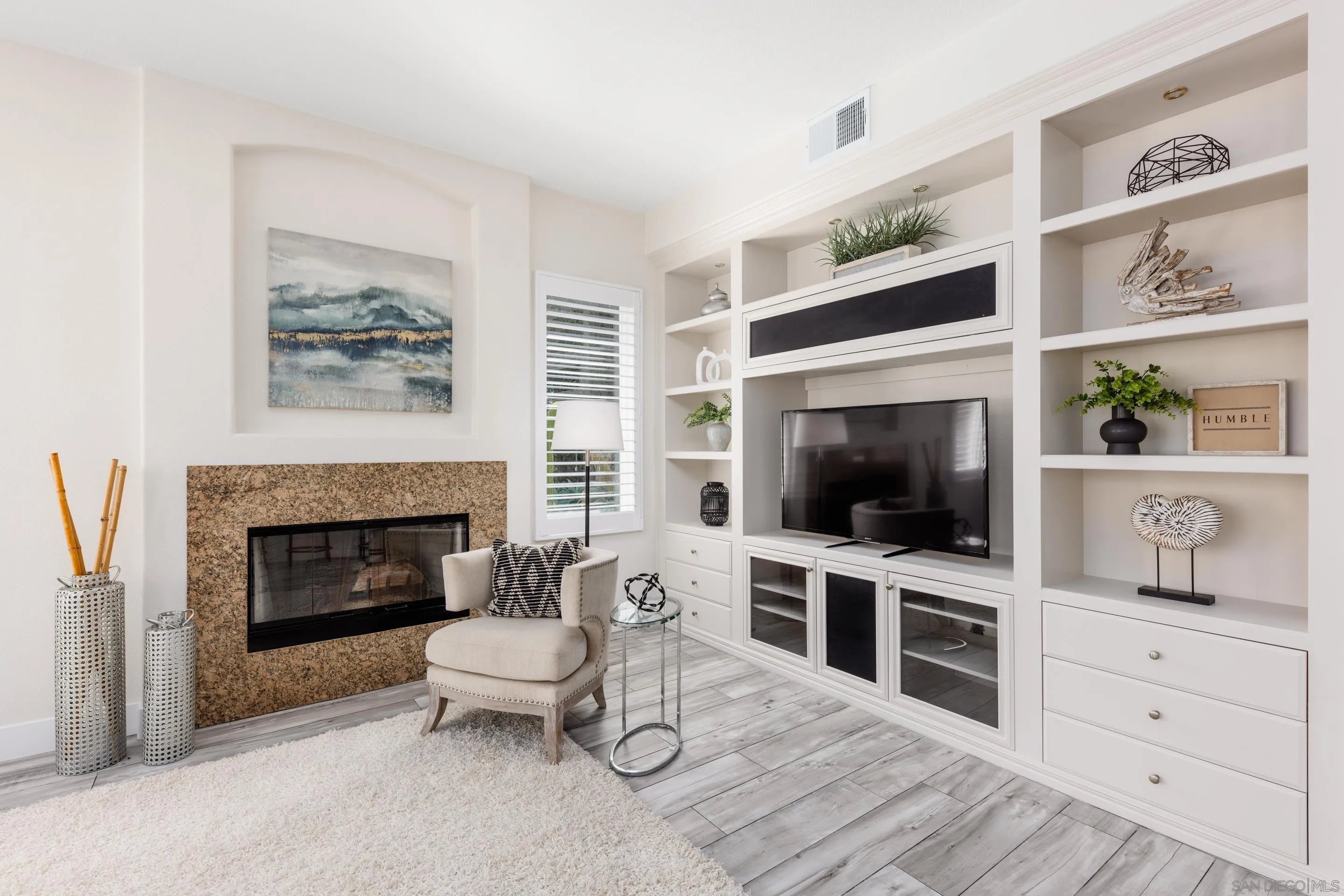 6814 Moorhen Place Carlsbad, CA 92011 - Photo 10 of 37 a living room with furniture a flat screen tv and a fireplace