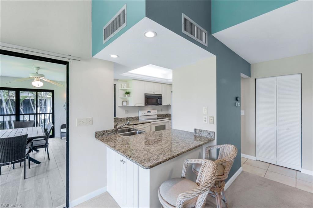 5585 Trailwinds Drive, Unit 326 Fort Myers, FL 33907 - Photo 14 of 37 a kitchen with a table chairs and entryway