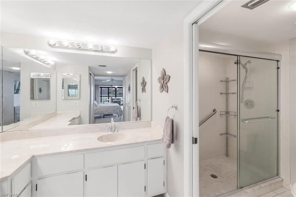5585 Trailwinds Drive, Unit 326 Fort Myers, FL 33907 - Photo 17 of 37 a bathroom with a shower sink and mirror