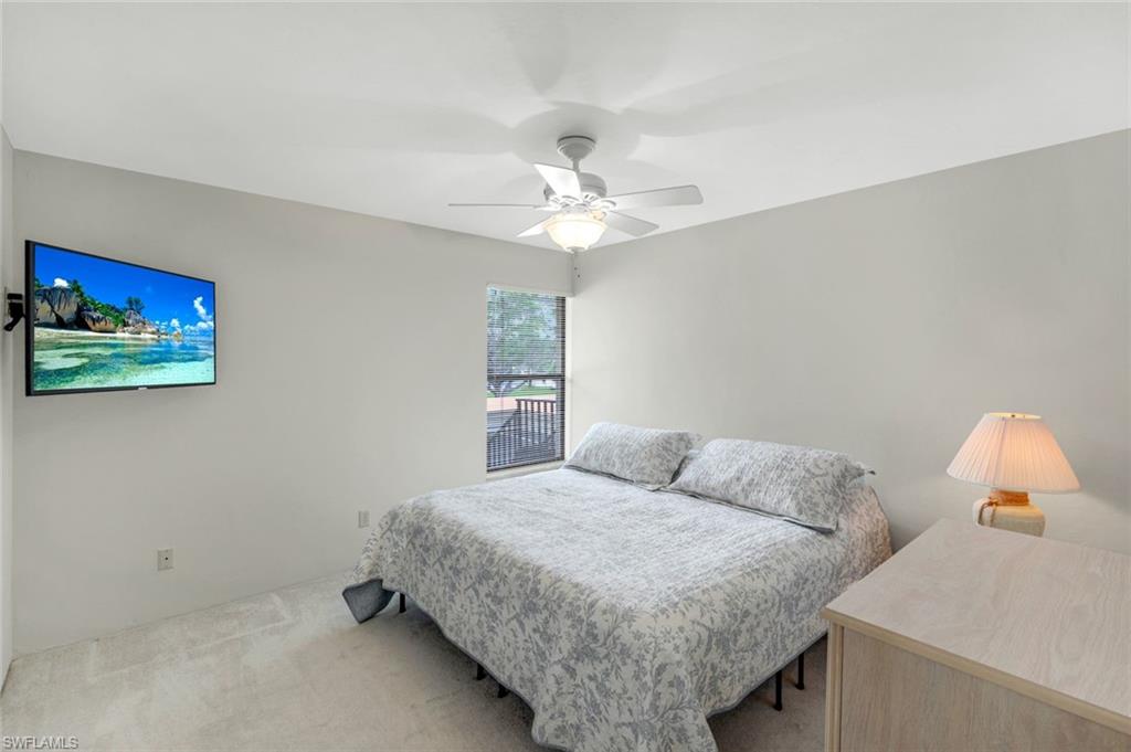 5585 Trailwinds Drive, Unit 326 Fort Myers, FL 33907 - Photo 19 of 37 a bedroom with a bed and a chandelier