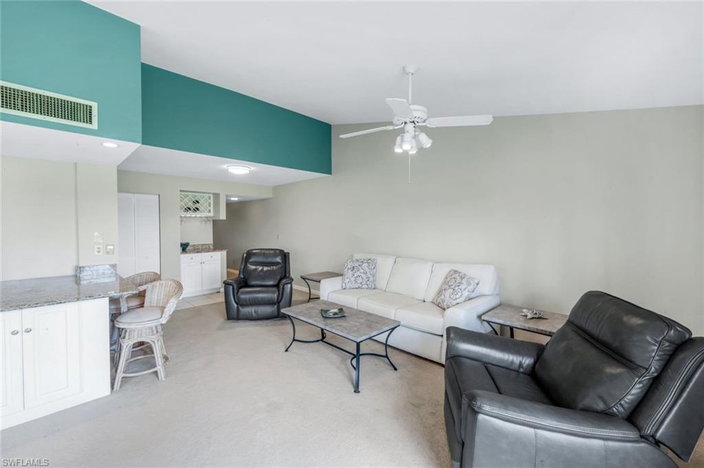5585 Trailwinds Drive, Unit 326 Fort Myers, FL 33907 - Photo 8 of 37 a living room with furniture and a chandelier