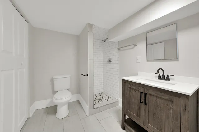 a spacious bathroom with a toilet a sink and a mirror