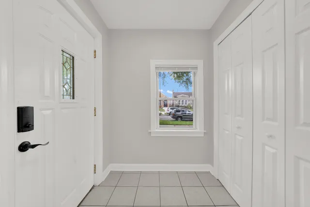 a view of an empty room with window and closet area