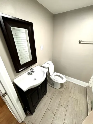 a bathroom with a toilet a sink and mirror
