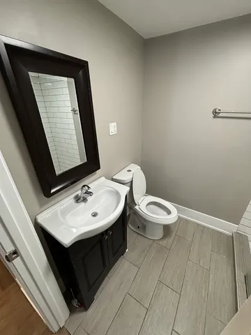 a bathroom with a toilet sink and mirror
