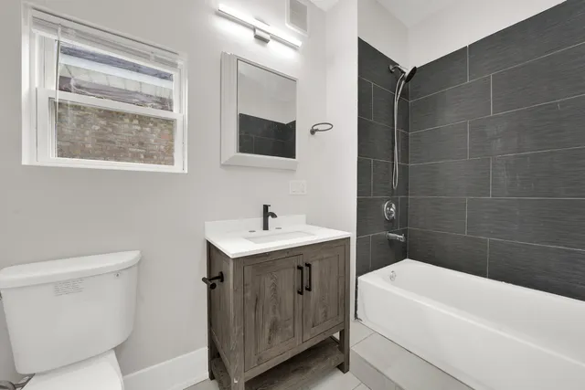 a bathroom with a toilet a sink a bath tub and mirror