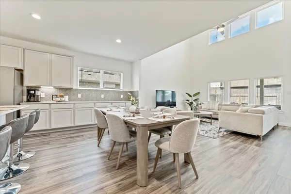a kitchen with a dining table chairs and wooden floor