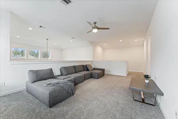 a living room with furniture and a ceiling fan