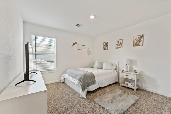 a spacious bedroom with a bed and a desk