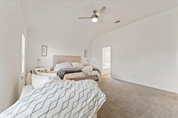 a bedroom with a large bed and a chandelier