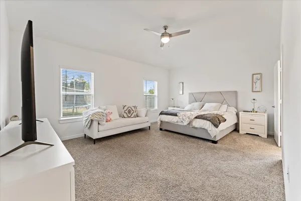 a bedroom with bed and a large window