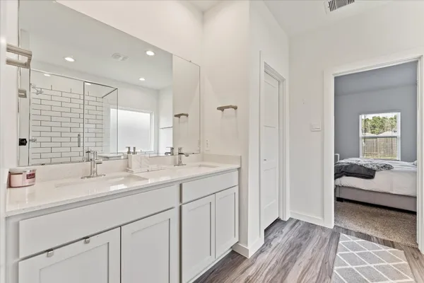 a en suite bathroom with a double vanity sink and mirror