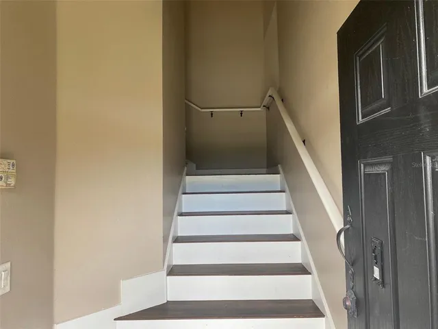 a view of staircase with white walls and a window