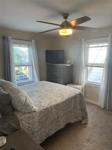 a bedroom with a bed and a large window