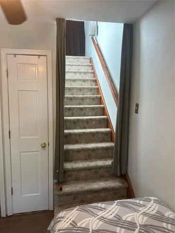 a view of a bedroom with wooden floor and white walls