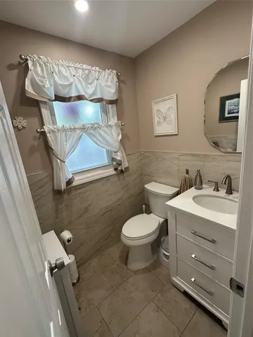 a bathroom with a toilet sink and mirror