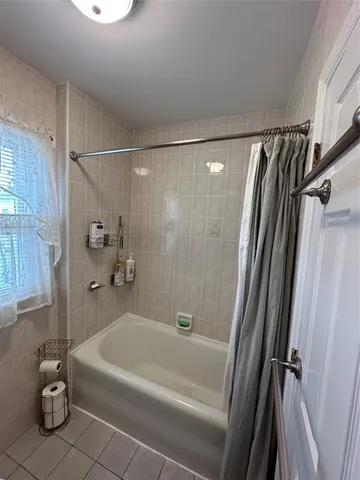 a bathroom with a tub a sink and a shower