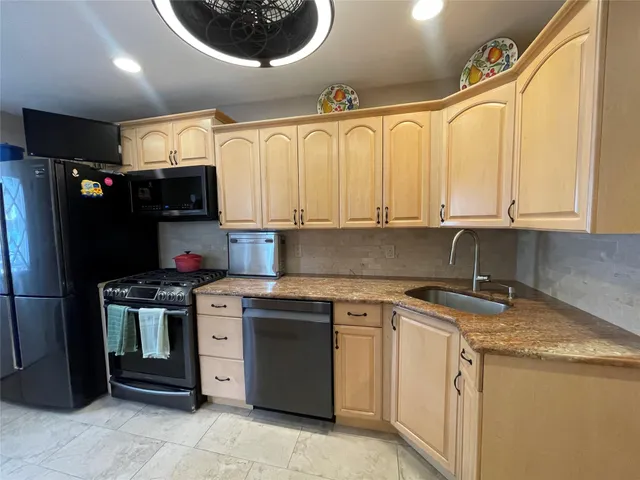 a kitchen with stainless steel appliances granite countertop a stove sink and cabinets