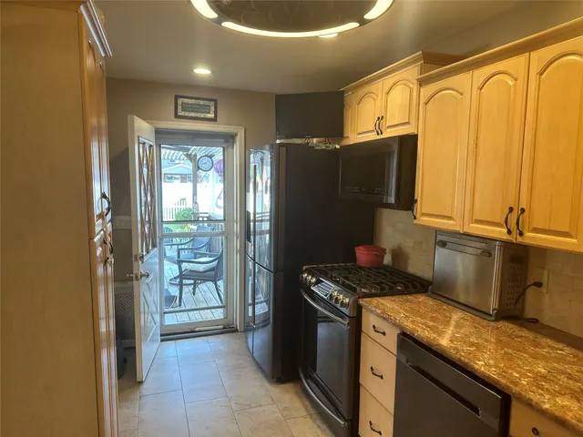 a kitchen with stainless steel appliances granite countertop a refrigerator and a stove