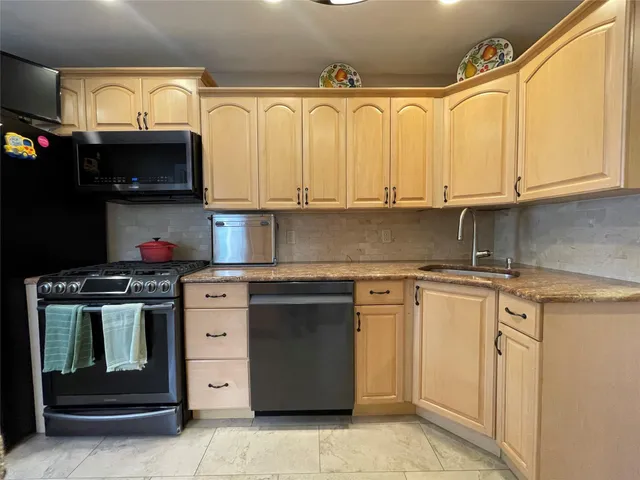 a kitchen with stainless steel appliances granite countertop a sink stove and cabinets