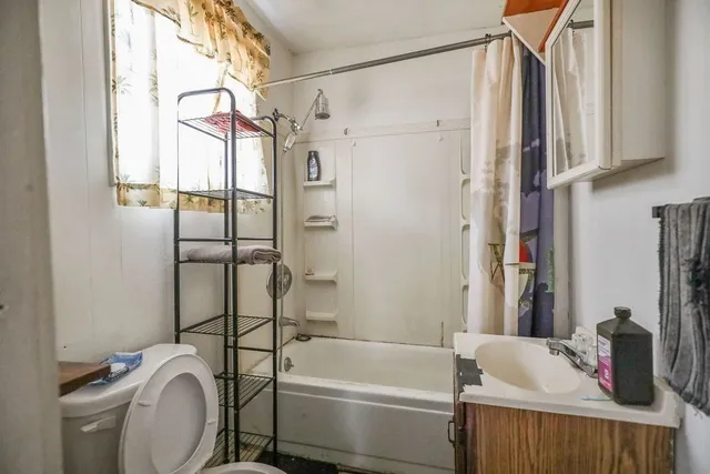 a bathroom with a sink a toilet and shower