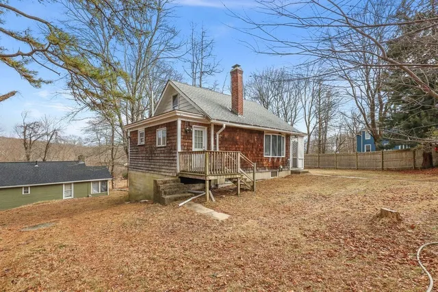 a view of a house with a yard chairs and iron fence