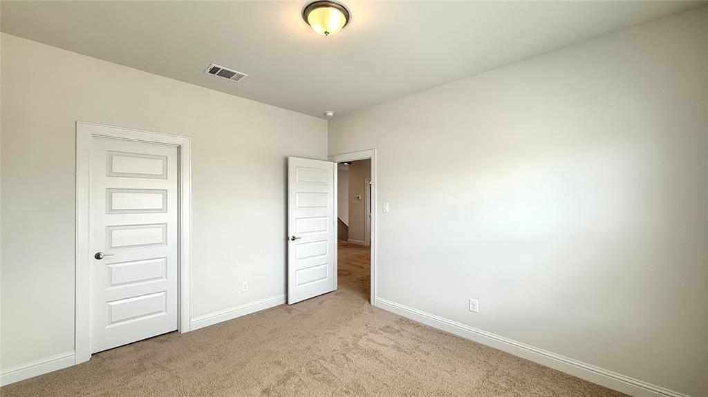 601 C-Bar Ranch Trail, Unit 27 Cedar Park, TX 78613 - Photo 17 of 29 Carpeted interior room featuring two modern five-panel doors, neutral wall paint, white baseboards, and a flush mount ceiling light