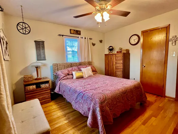 a bedroom with a bed and a flat tv screen on dresser