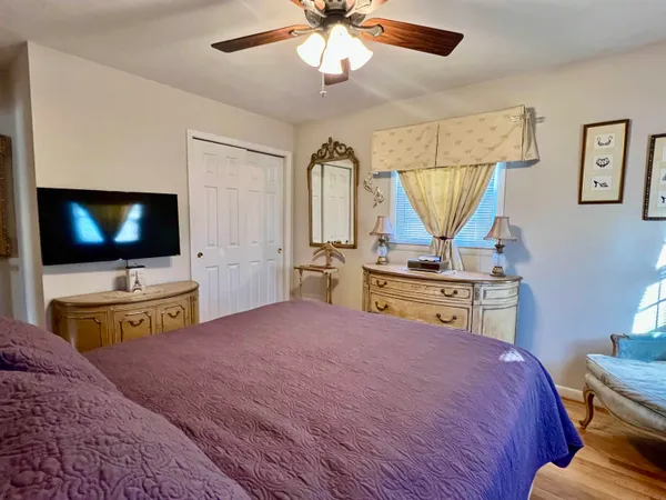 a bedroom with a bed a dresser and next to a window