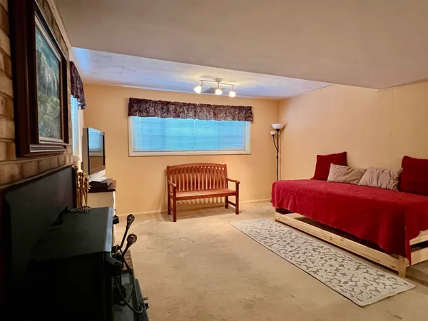 a bedroom with a bed and a chair with the front door