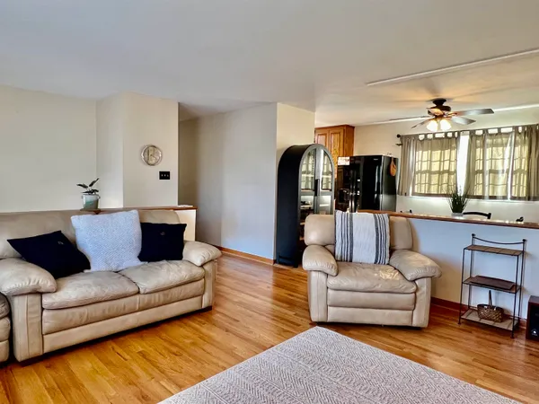 a living room with furniture and view of kitchen