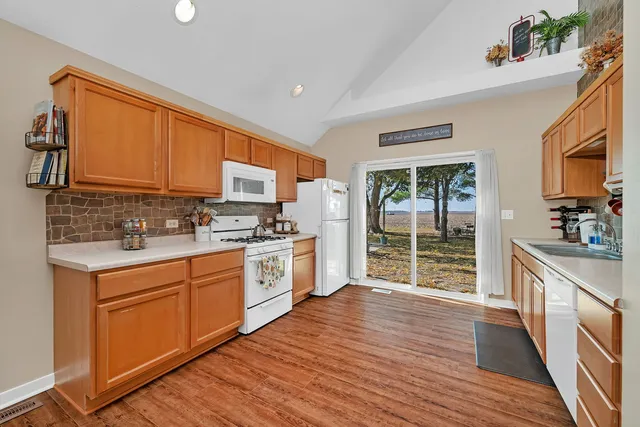 a kitchen with stainless steel appliances granite countertop a stove a sink dishwasher and a microwave oven with wooden floor