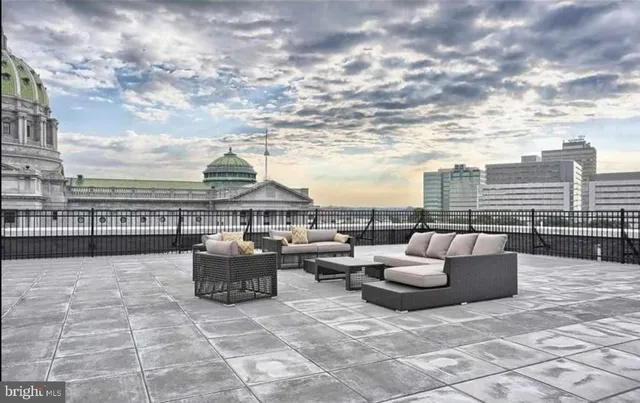 a view of roof deck with couches and city view