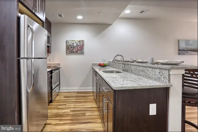 a kitchen with granite countertop a refrigerator and a sink
