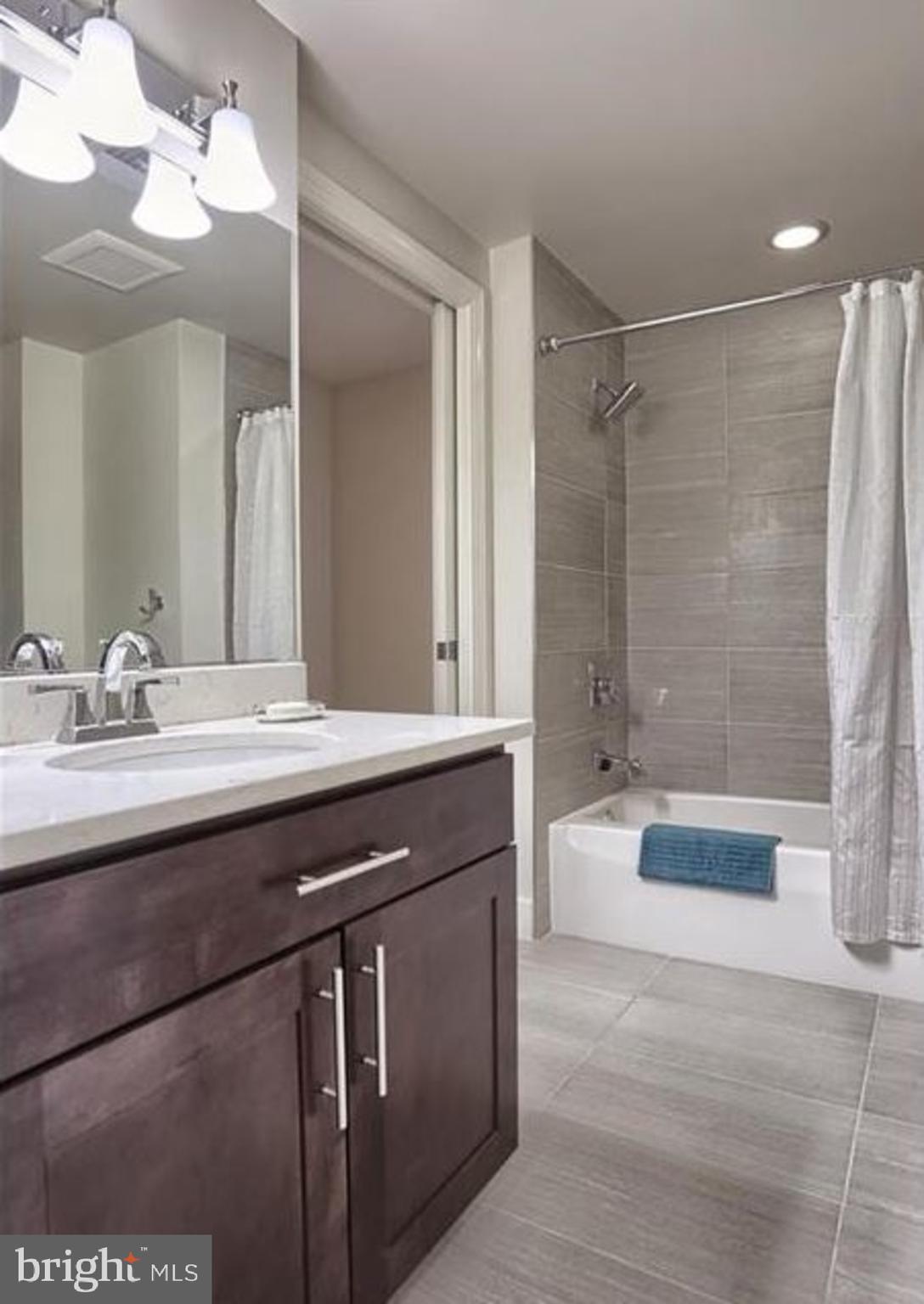 231 State Street, Unit 802 Harrisburg, PA 17101 - Photo 7 of 27 a bathroom with a granite countertop sink a toilet a mirror a bathtub and shower