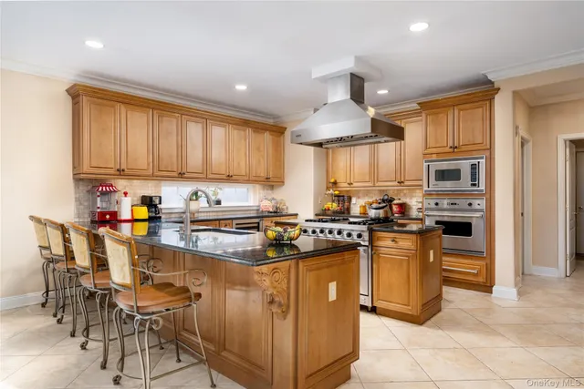 a kitchen with stainless steel appliances granite countertop a stove top oven a sink dishwasher and a refrigerator