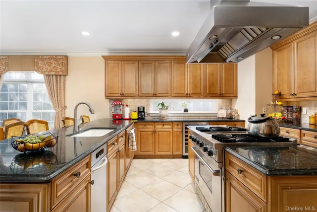 a kitchen with granite countertop a sink a counter top space a stove and cabinets