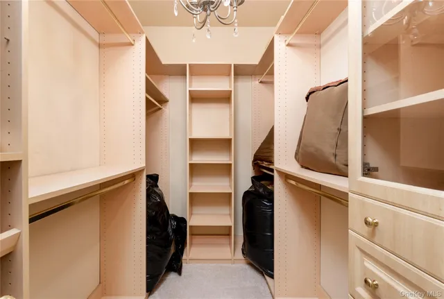 a view of a livingroom with furniture wooden floor windows and a chandelier