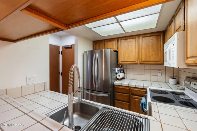 a kitchen with granite countertop a sink and a stove top oven
