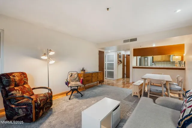 a living room with furniture a air conditioner vent and a window