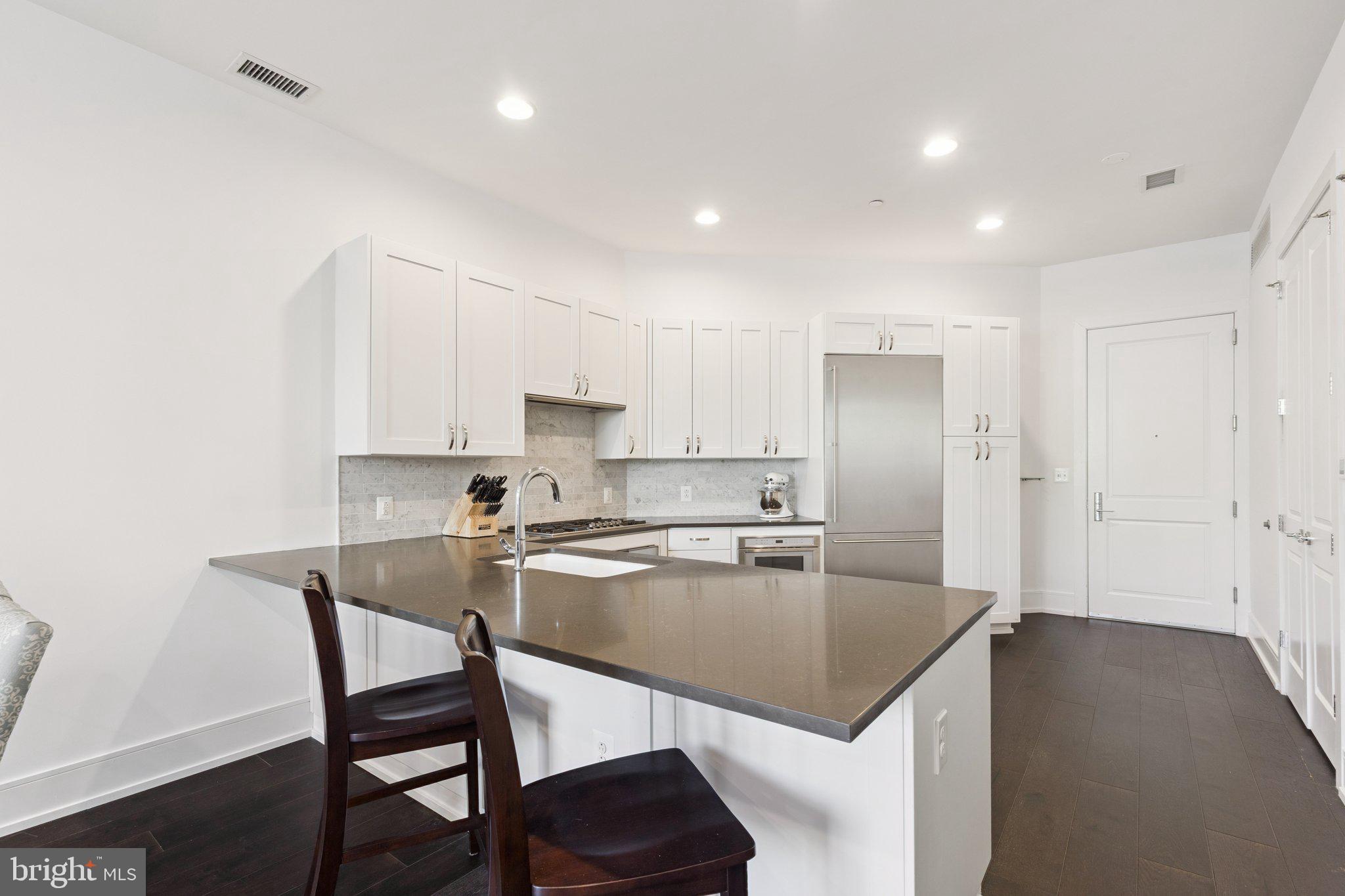 410 South Front Street, Unit 108 Philadelphia, PA 19147 - Photo 11 of 34 a kitchen with a table chairs microwave and cabinets