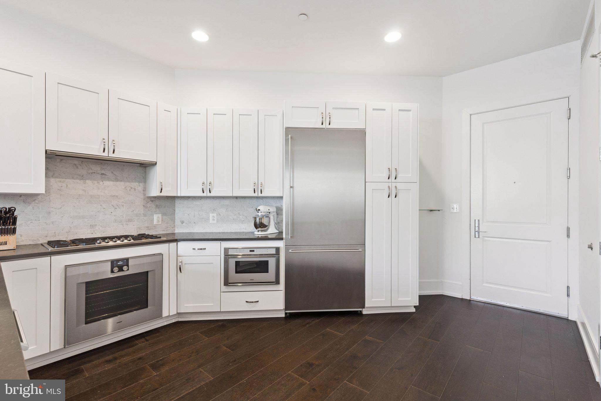 410 South Front Street, Unit 108 Philadelphia, PA 19147 - Photo 10 of 34 a kitchen with stainless steel appliances granite countertop a refrigerator a stove and white cabinets