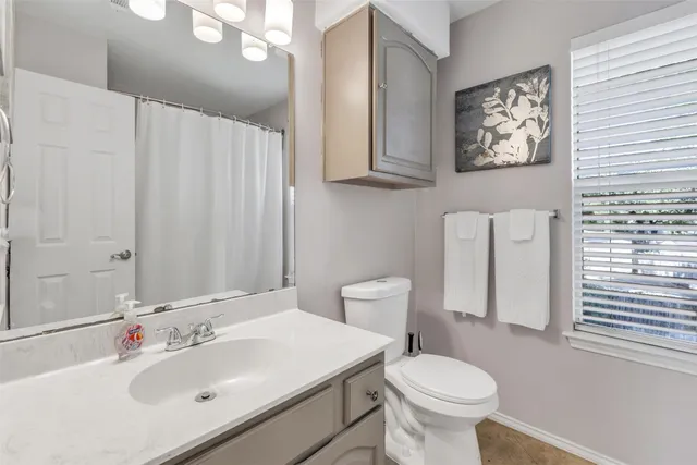 a bathroom with a sink toilet and a mirror
