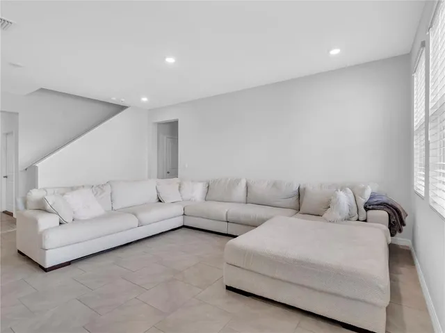 a living room with furniture and kitchen view