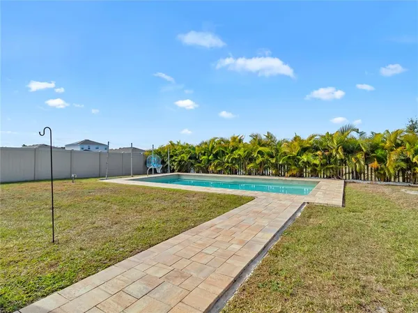 a view of a house with a yard and potted plants