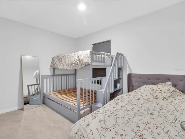 a spacious bedroom with two beds and lamp