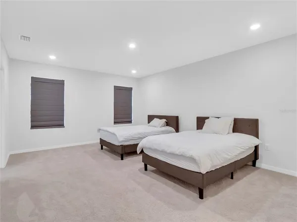 a spacious bedroom with a bed and a night stand