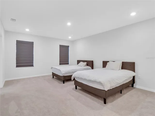 a spacious bedroom with a bed and a night stand