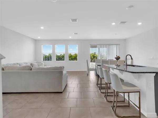 a kitchen with kitchen island granite countertop a sink counter and chairs